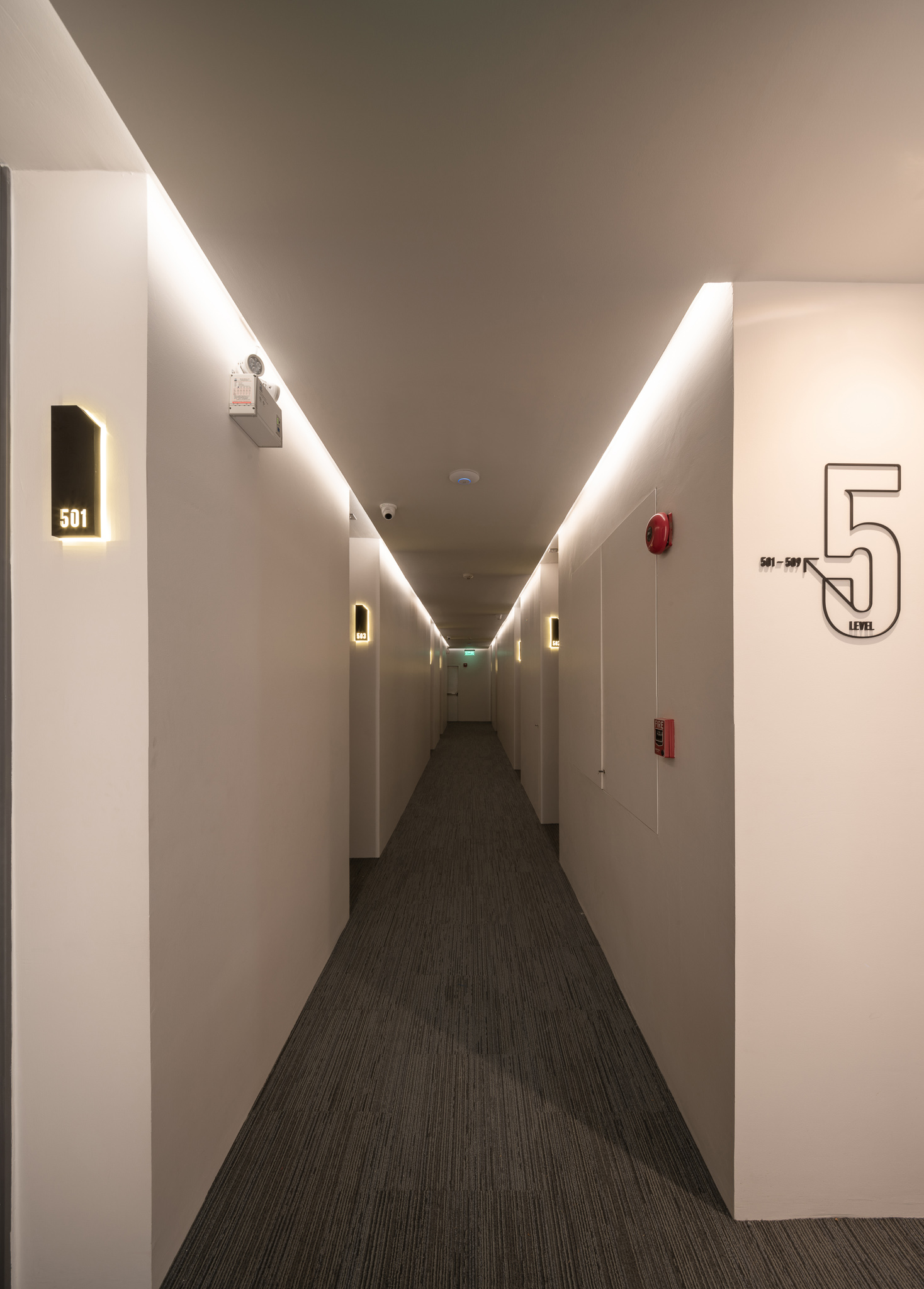Guest room corridor with warm cove lighting