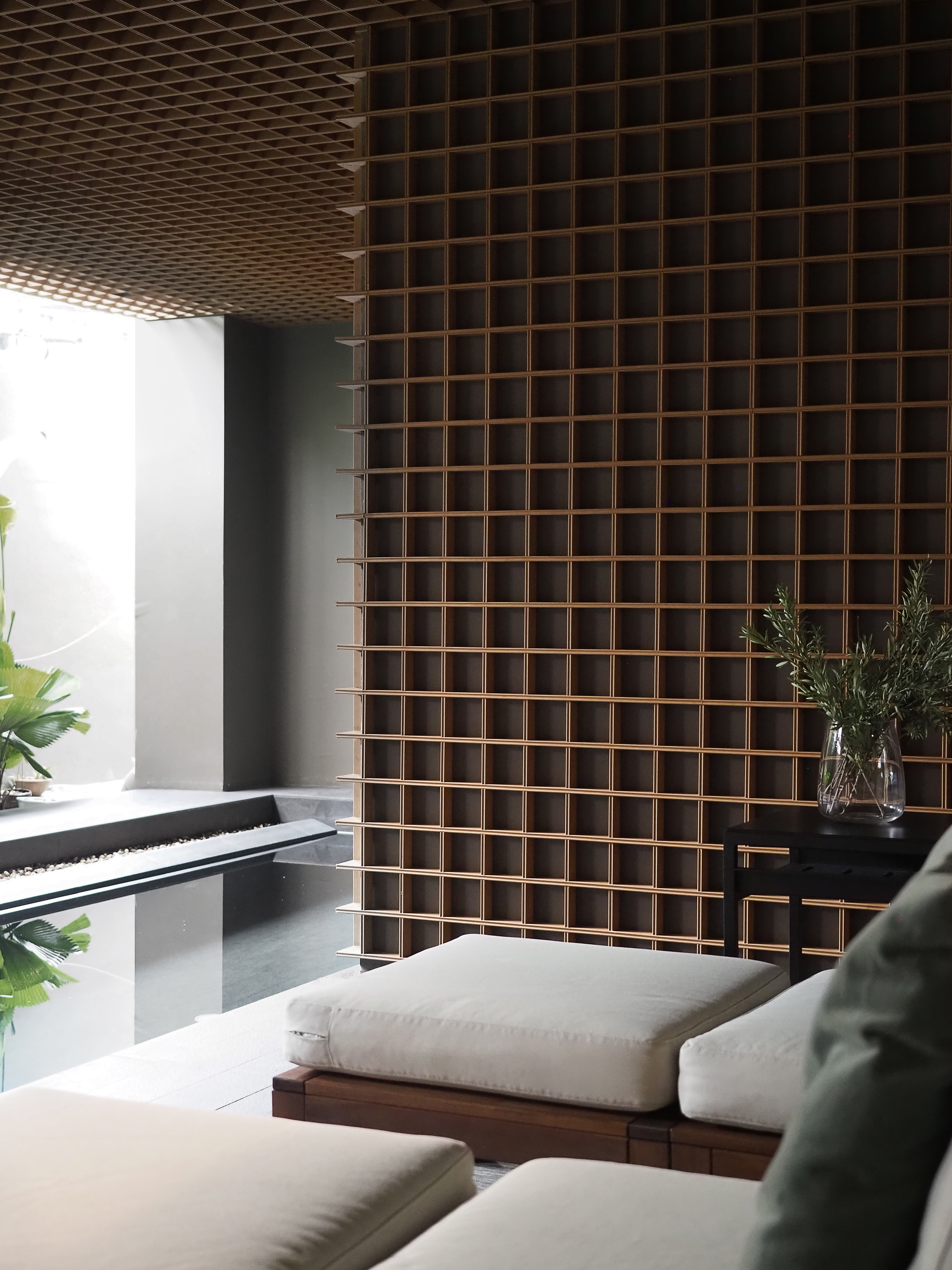 Wooden lattice interior with reflecting pool and tropical plants
